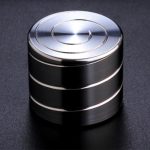 Giroscópio anti-stress de metal com superfície brilhante, vista de cima, mostrando os círculos concêntricos no topo.