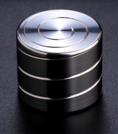 Giroscópio anti-stress de metal com superfície brilhante, vista de cima, mostrando os círculos concêntricos no topo.