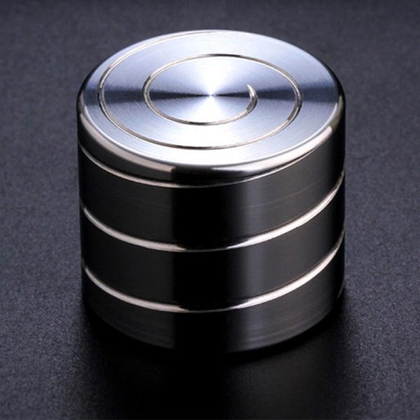 Giroscópio anti-stress de metal com superfície brilhante, vista de cima, mostrando os círculos concêntricos no topo.