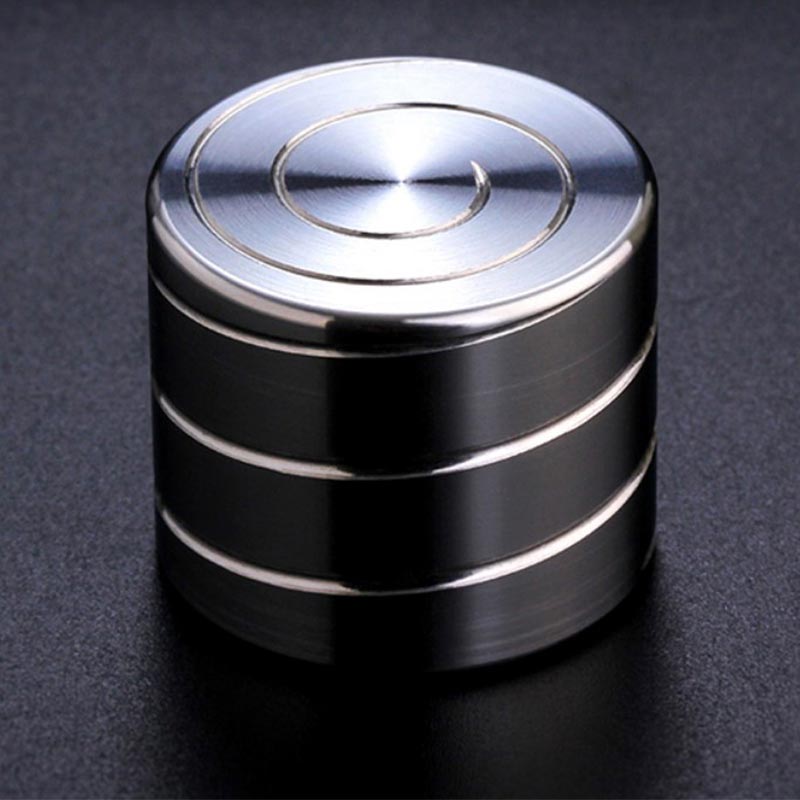 Giroscópio anti-stress de metal com superfície brilhante, vista de cima, mostrando os círculos concêntricos no topo.
