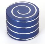 Giroscópio anti-stress azul com padrão de espiral branco na parte superior, mostrado de cima, com várias camadas visíveis.