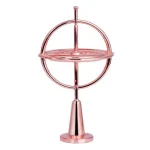 Giroscópio de precisão com estrutura metálica rosé, base cônica e esfera rotativa central, usado para demonstrações científicas de física.