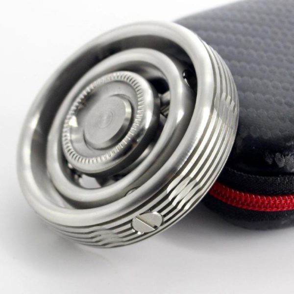 Giroscópio Fidget Spinner com acabamento metálico, detalhes circulares e mecanismo de rotação visível, junto de estojo preto com fecho vermelho.