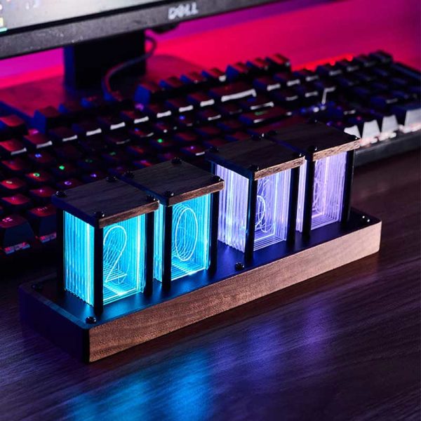 Relógio Nixie com tubos de vidro iluminados exibindo números azuis, colocado numa base de madeira junto a um teclado de computador.