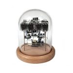 Relógio Nixie com tubos de vidro, componentes eletrónicos visíveis, protegido por uma cúpula de vidro sobre base de madeira.