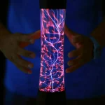 Pessoa segurando uma lâmpada de plasma em tubo, com descargas elétricas visíveis e cores vibrantes, em ambiente escuro.