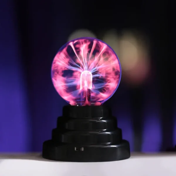 Lâmpada de plasma USB de 15 cm com faíscas de energia visíveis dentro de uma esfera de vidro, sobre base preta, com efeito de luzes coloridas e brilho intenso.