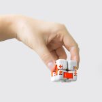 Mão a segurar um Cubo Infinito com peças brancas e detalhes laranja, mostrando o design modular e a flexibilidade do produto.