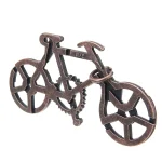 Peça de quebra-cabeça de bicicleta de metal com rodas abertas e estrutura detalhada, vista de lado.