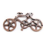 Quebra-cabeça de bicicleta em metal com várias peças interligadas, vista de cima, com detalhes das engrenagens e rodas.