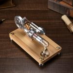 Motor Stirling de ar quente com componentes metálicos e base de madeira, mostrando detalhes do mecanismo e pistões em uma mesa de madeira.