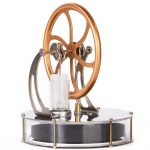 Motor Stirling com roda de metal dourada, pistão e base de vidro, usado em demonstrações científicas de termodinâmica.