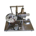 Motor Stirling de metal prateado com componentes visíveis, incluindo pistão, cilindro e mecanismo de ligação, montado numa base de metal.