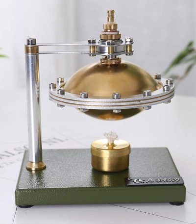 Motor Stirling com componentes metálicos dourados e prateados, base verde escura, mostrando o funcionamento com vapor de água.