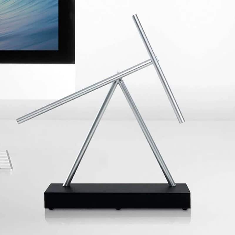 Pêndulo de Newton Bastão com hastes de metal e base preta, demonstrando o movimento de colisão de esferas.