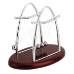 Pêndulo de Newton com estrutura de metal prateado, bolas de aço e base de madeira escura, exibindo movimento de balanço.