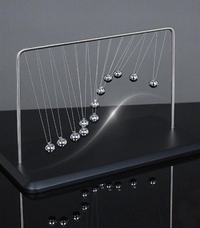Pêndulo de Newton gigante com bolas metálicas suspensas por fios finos, exibindo movimento de colisão e energia.