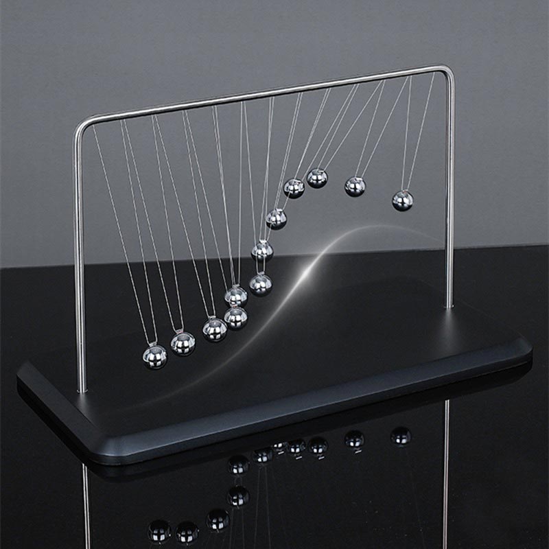 Pêndulo de Newton gigante com bolas metálicas suspensas por fios finos, exibindo movimento de colisão e energia.