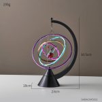 Pêndulo de Newton decorativo com órbitas neon coloridas representando o Sistema Solar, suportado por base preta com altura de 30.5cm e diâmetro de 23cm.