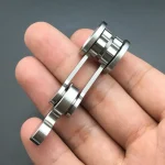 Peça de metal com várias camadas e uma alavanca, usada em experimentos científicos ou demonstrações educativas.