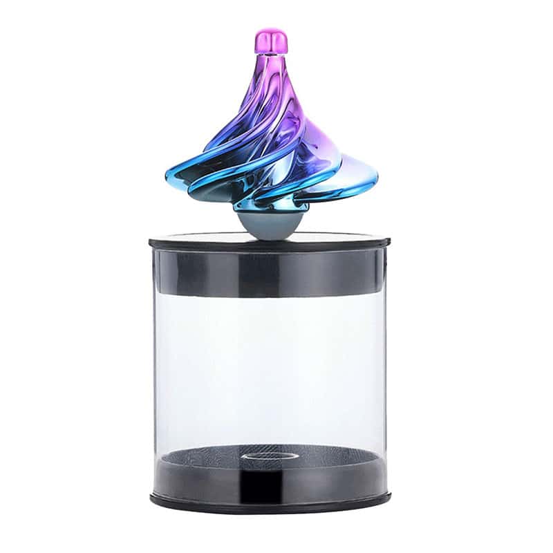 Pião giroscópio com corpo de vidro colorido em tons de azul e roxo, colocado numa base transparente com tampa preta, mostrando o movimento do brinquedo.