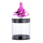 Pião giroscópio de vidro rosa com base transparente, mostrando movimento de rotação, em recipiente de exibição transparente.