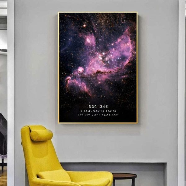 Cartaz com imagem de uma nebulosa colorida no espaço, com detalhes de estrelas e gás interestelar, em moldura dourada, pendurado numa parede cinzenta.