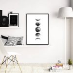 Poster decorativo com as diferentes fases da Lua, em preto e branco, pendurado numa parede branca moderna.
