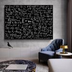 Quadro grande na parede com várias fórmulas científicas e matemáticas em branco sobre fundo preto, numa sala moderna com cadeira azul e mesa de canto.
