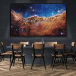 Grande tela exibindo uma nebulosa colorida com estrelas brilhantes e gás cósmico, em ambiente de sala de aula ou apresentação.