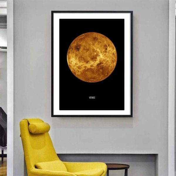 Fotografia de um poster do planeta Vénus com detalhes da sua superfície, em moldura preta numa parede branca, com uma cadeira amarela ao lado.