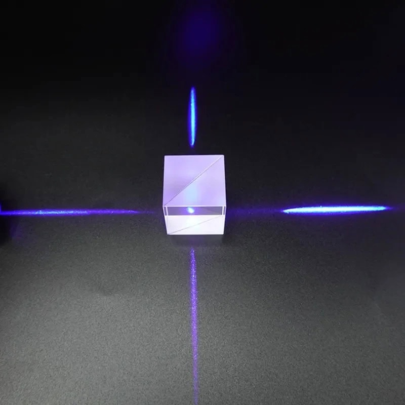 Prisma cúbico transparente com feixes de luz azul dispersos em diferentes direções, mostrando dispersão de luz através do prisma.