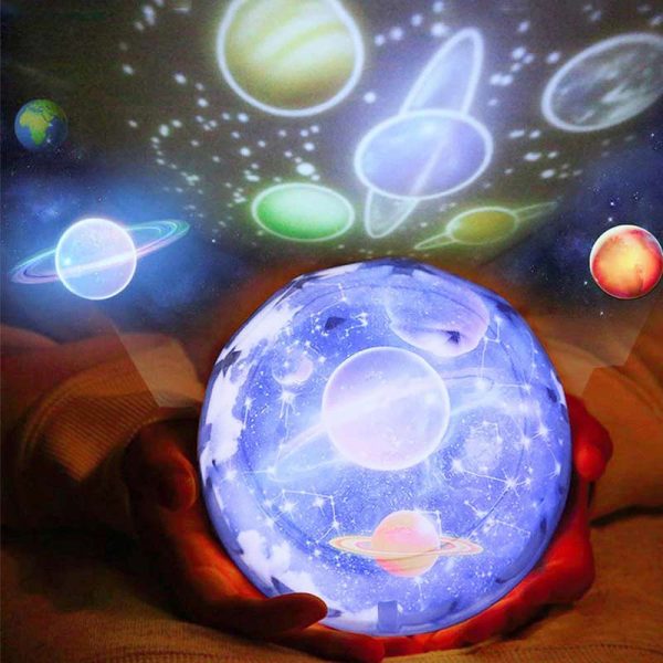 Mãos segurando esfera com projeção de planetas e estrelas, luzes coloridas de galáxia e sistema solar.