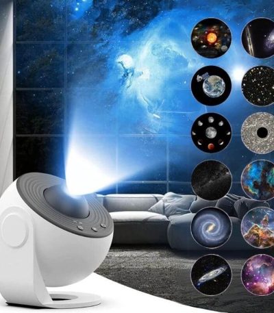 Projetor de galáxia com várias projeções de estrelas, planetas e nebulosas, exibido numa sala escura com sofá ao fundo.