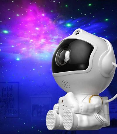Robô projetor com forma de astronauta, projetando estrelas e galáxias coloridas no teto, ideal para ambientes educativos e de lazer.