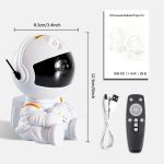 Mini projetor de nebulosa com design de astronauta, incluindo controle remoto, cabo USB e manual de instruções, com dimensões de 8,5cm por 12,5cm.