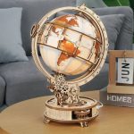 Globo terrestre em madeira com mecanismo de horas e iluminação, detalhes de continentes e linhas de longitude visíveis, colocado numa mesa de sala de estar.