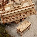 Piano de madeira detalhado com banco à frente, ambos com acabamento em madeira clara, em ambiente natural com musgo e pedra.