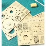 Peças de madeira para montar um puzzle 3D luminoso, com detalhes intricados e diferentes formas, sobre uma mesa de trabalho com ferramentas e materiais de corte.
