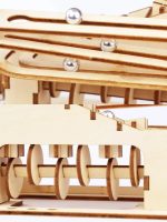 Detalhe de várias peças de madeira do puzzle mecânico, incluindo esferas metálicas e rodas, mostrando diferentes ângulos e componentes do produto.