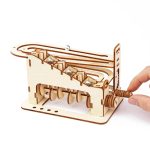 Labirinto de bolas de madeira com percurso em espiral e mecanismo de manivela, para manipular bolas de metal ao longo do percurso.