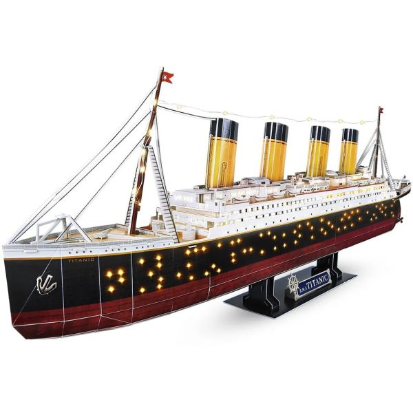Modelo do Titanic com iluminação LED, detalhes do casco, chaminés e velas, vista lateral, destaque para as luzes acesas na parte inferior do navio.