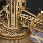 Detalhe de um relógio de madeira mecânico com engrenagens visíveis e ponteiros em movimento, mostrando a complexidade do mecanismo artesanal.
