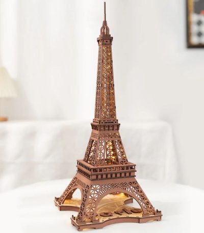 Miniatura da Torre Eiffel em peças de madeira, com iluminação interna, vista frontal detalhada.