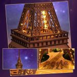 Modelo de torre Eiffel em madeira com iluminação interna, vista de cima, detalhes do design e base com a palavra 'Paris' em relevo.