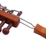Peças de madeira do puzzle chinês com pinos e uma ferramenta de montagem.