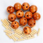 Bolas de madeira com buracos e palitos de madeira, componentes para construir modelos de átomos.