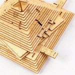 Peças de madeira de diferentes tamanhos e formas empilhadas, usadas para montar um quebra-cabeças tridimensional de pirâmide.