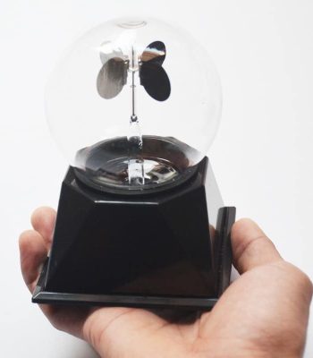 Radiómetro meteorológico com esfera de vidro transparente, hélices metálicas e base preta, usado para medir radiação solar.