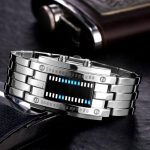 Relógio de pulso com visor digital que mostra hora em formato binário, com pulseira de metal prateada e detalhes em preto.